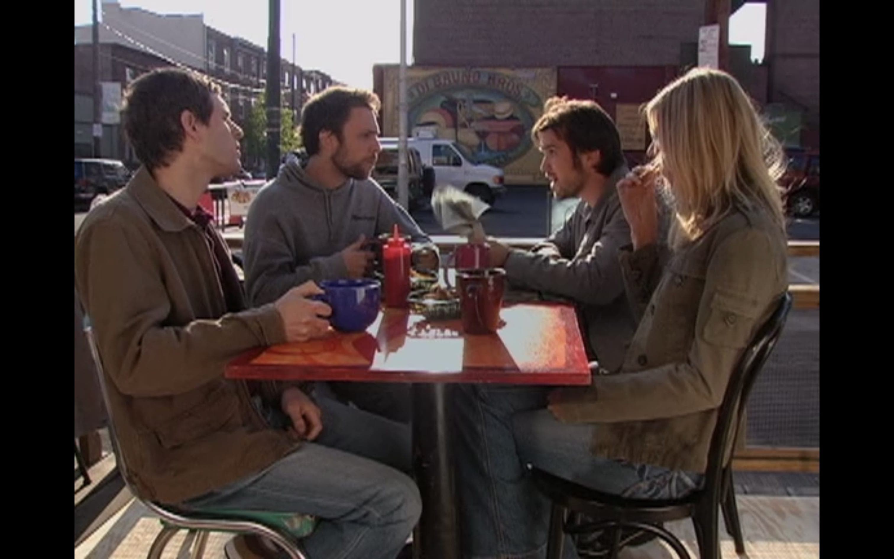 The gang sitting at a table opposite the Di Bruno Bros mural in the Italian Market.